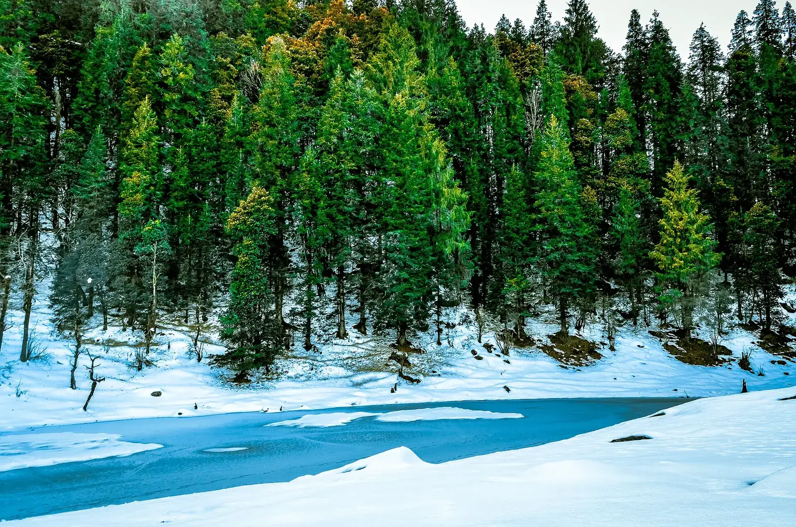 Frozen Juda ka Talab lake in snow on the Kedarkantha trek