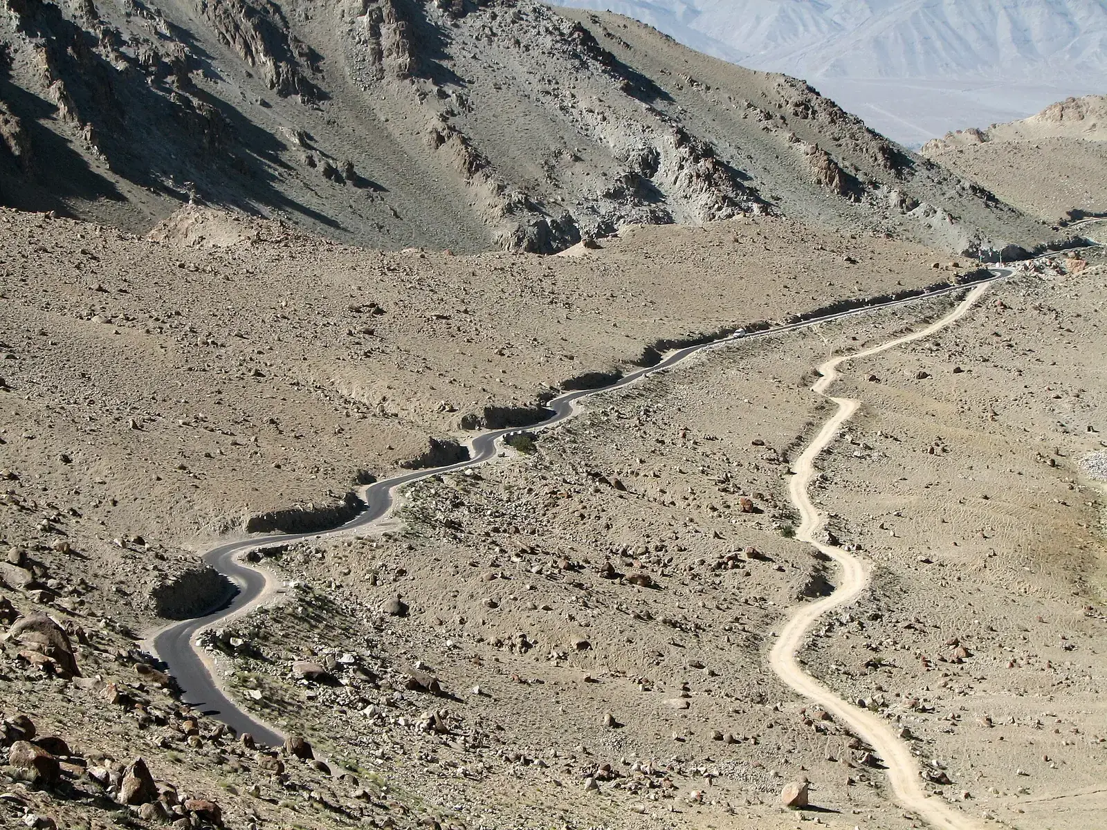 Paved and dirt roads snaking up the mountainside on the Khardung La road, Ladakh