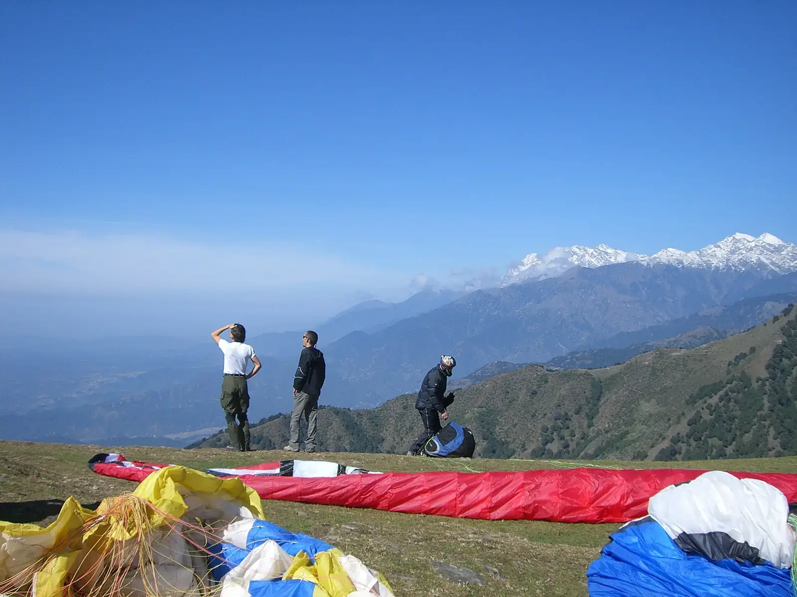Paragliding pilots at the Billing take-off with the Dhauladhar range behind