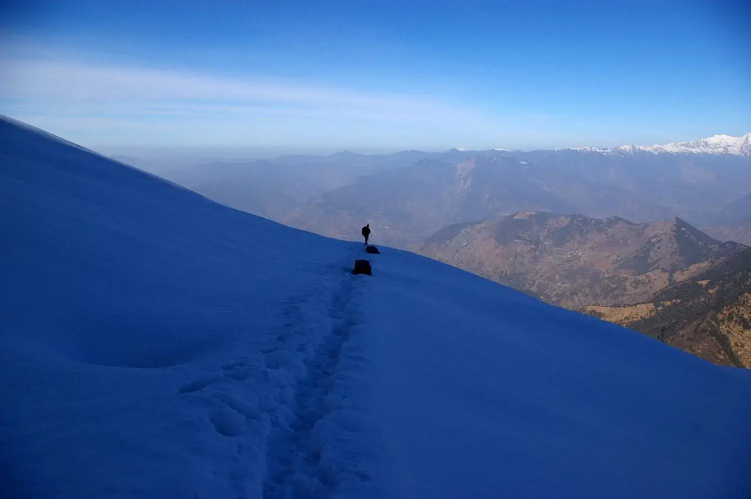 Trekkers on a snow-covered path to Tungnath