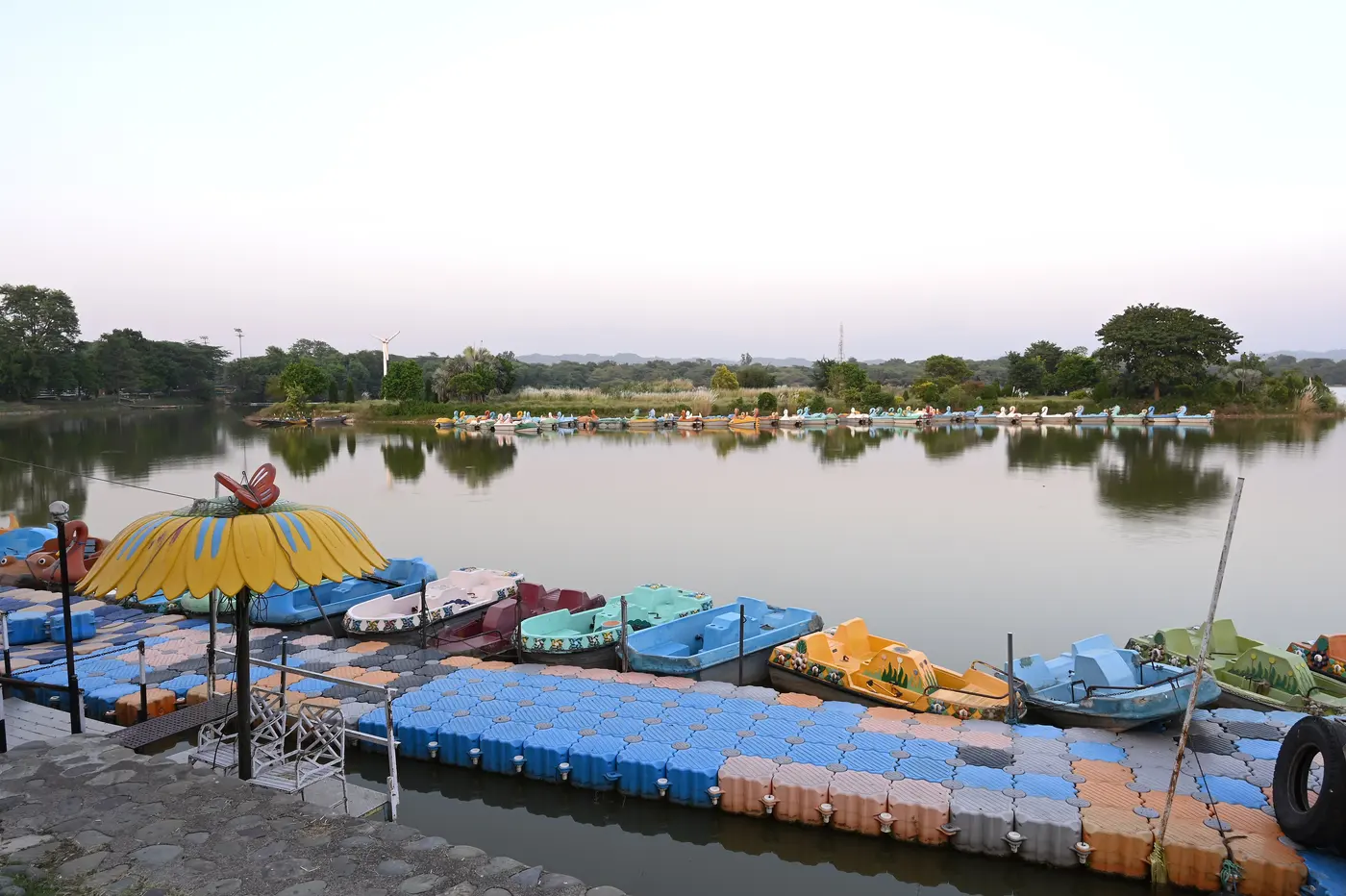 Pedal boats moored along the promenade at Sukhna Lake, Chandigarh, at dusk