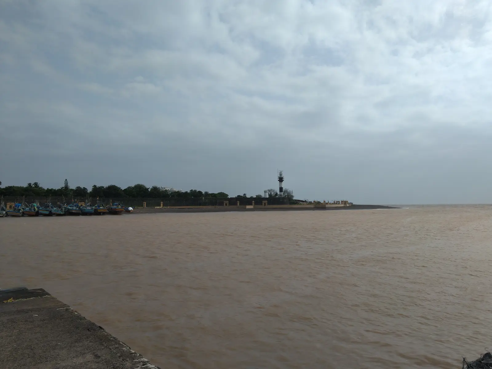 View along Moti Daman Fort's sea wall toward the Daman lighthouse and the Daman Ganga river mouth