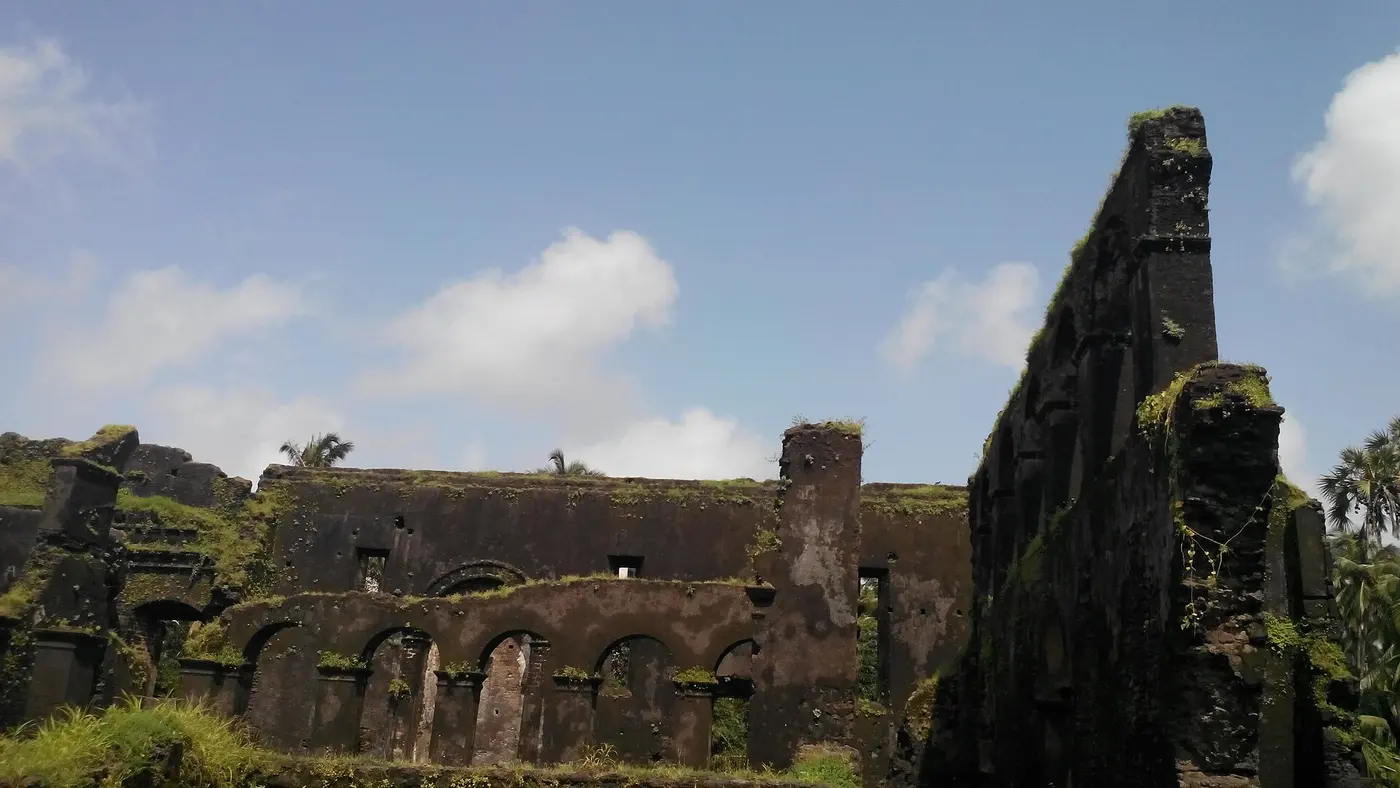 The roofless stone arcade and moss-covered ruins of the Dominican Monastery in Moti Daman's old town