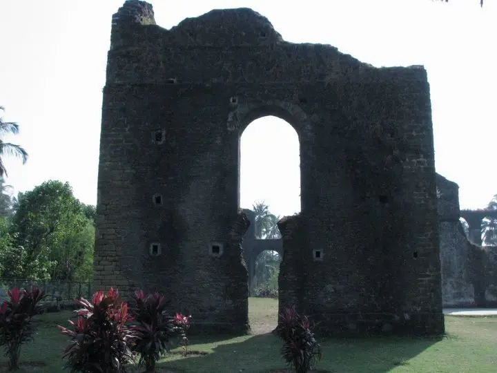 A moss-covered inner archway and old cannon emplacement along Moti Daman Fort's ramparts