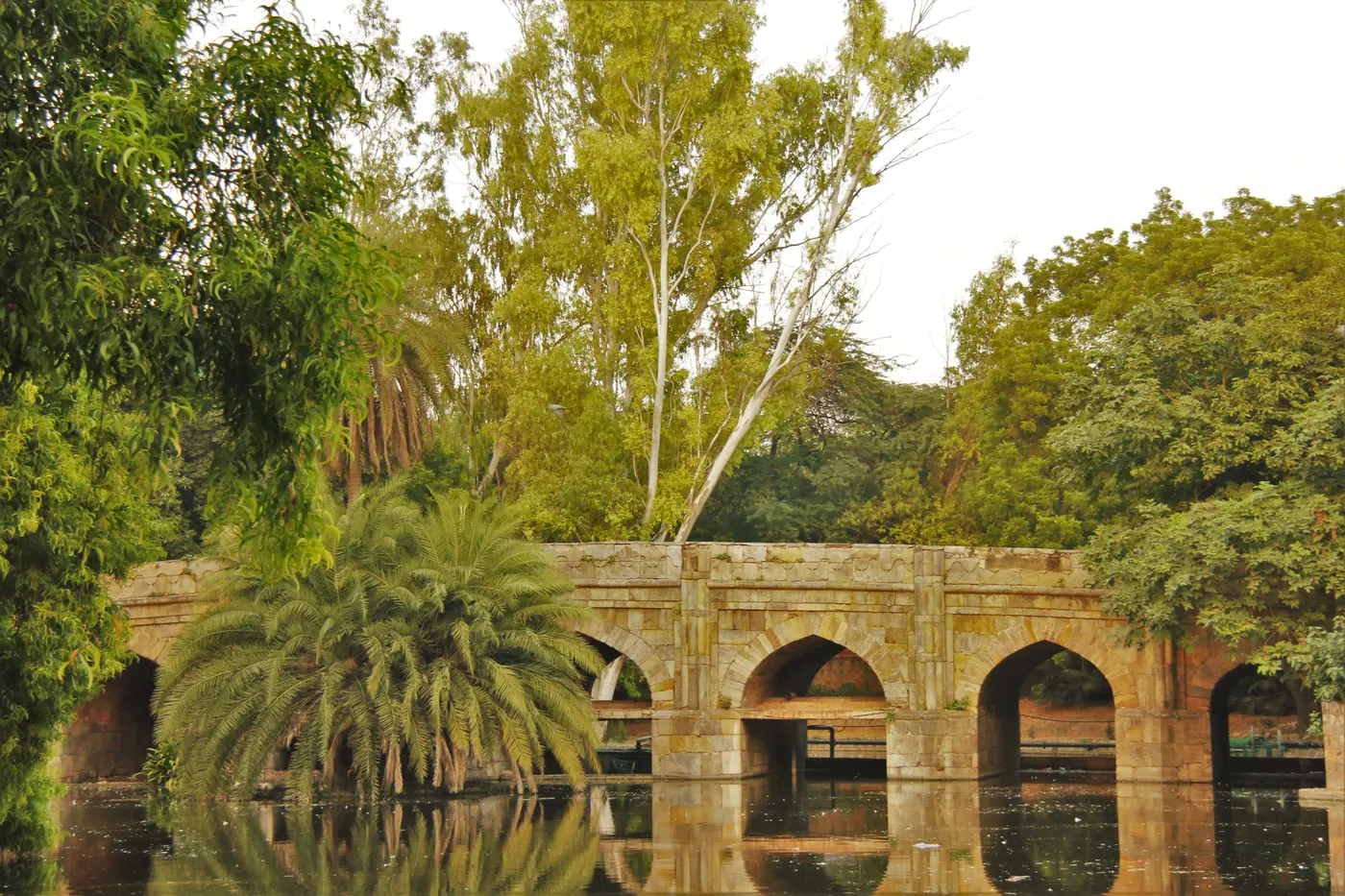 The stone-arched Athpula bridge spanning the dry streambed in Lodhi Garden's northern end