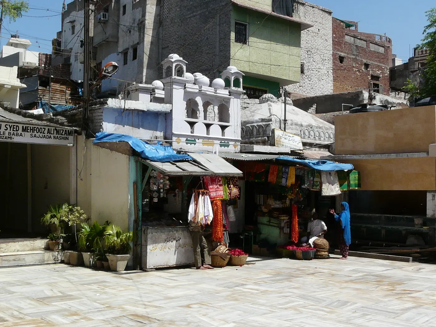 Flower and chadar shops lining the edge of the Nizamuddin Dargah courtyard in Delhi