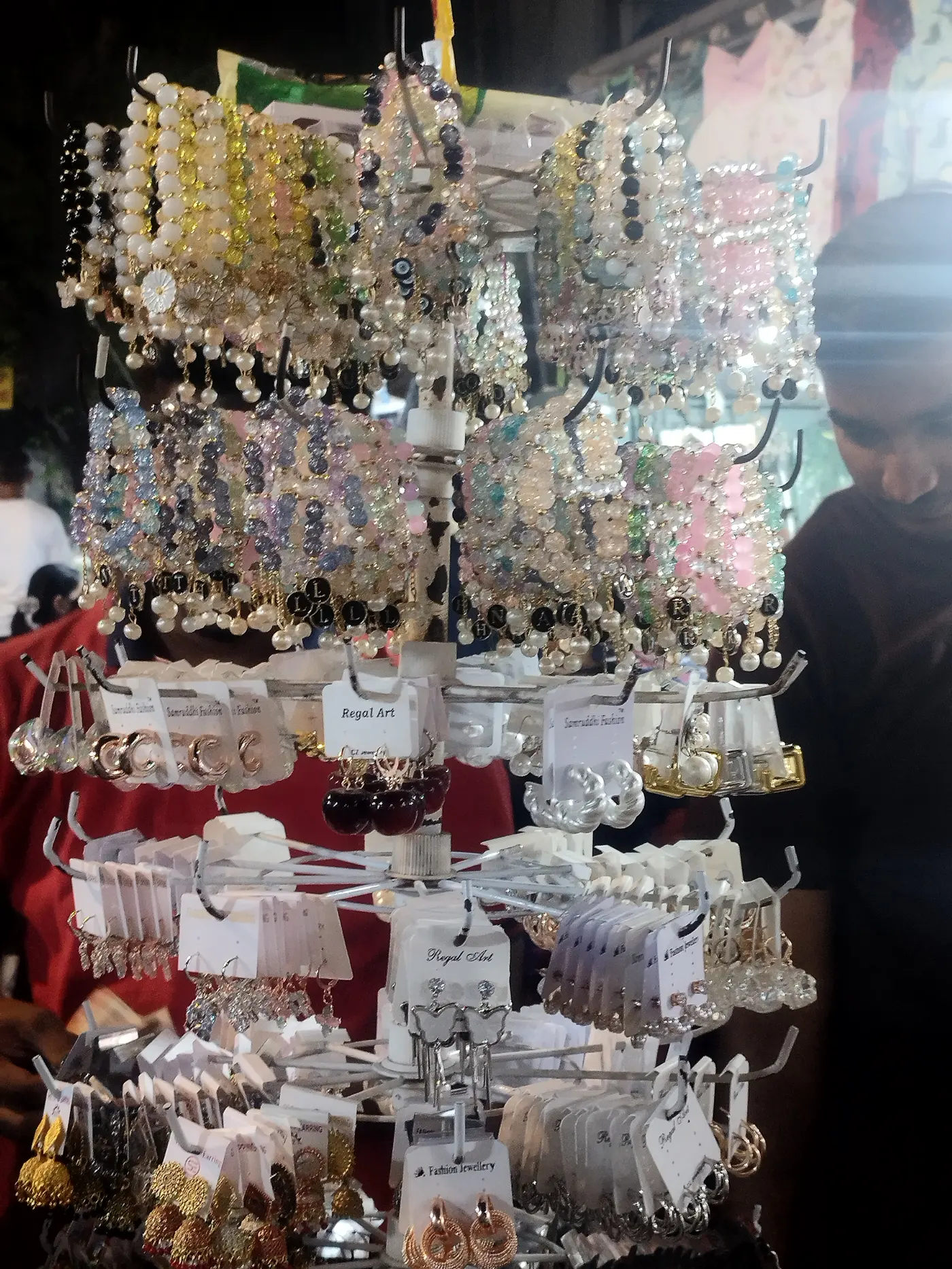 A tiered accessory stall hung with earrings, bracelets, and costume jewellery at Sarojini Nagar Market