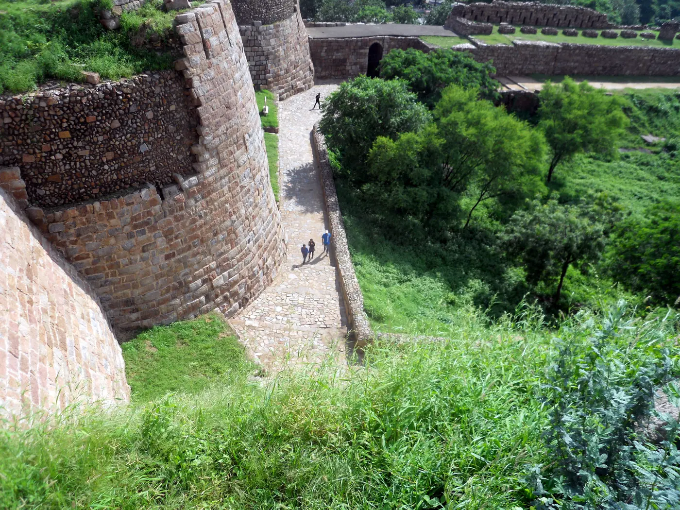 One of Tughlaqabad Fort's surviving stone gates, framing a view through to the ruins beyond
