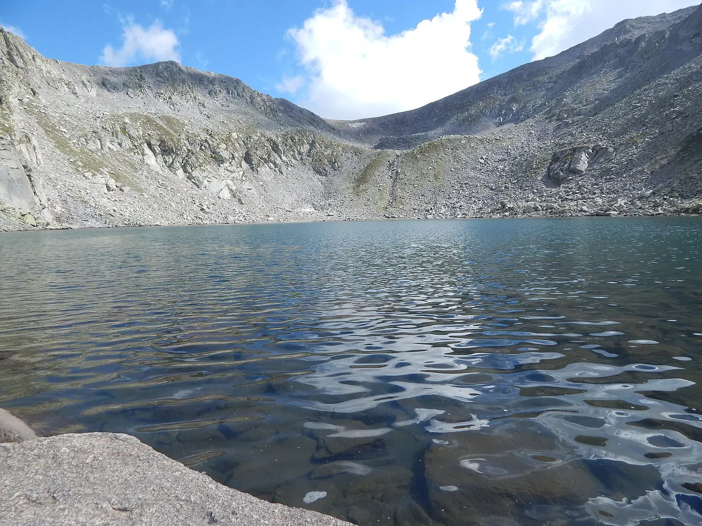 Kailash Kund, a glacial lake ringed by bare scree slopes high in the Bhaderwah Kailash range above the town