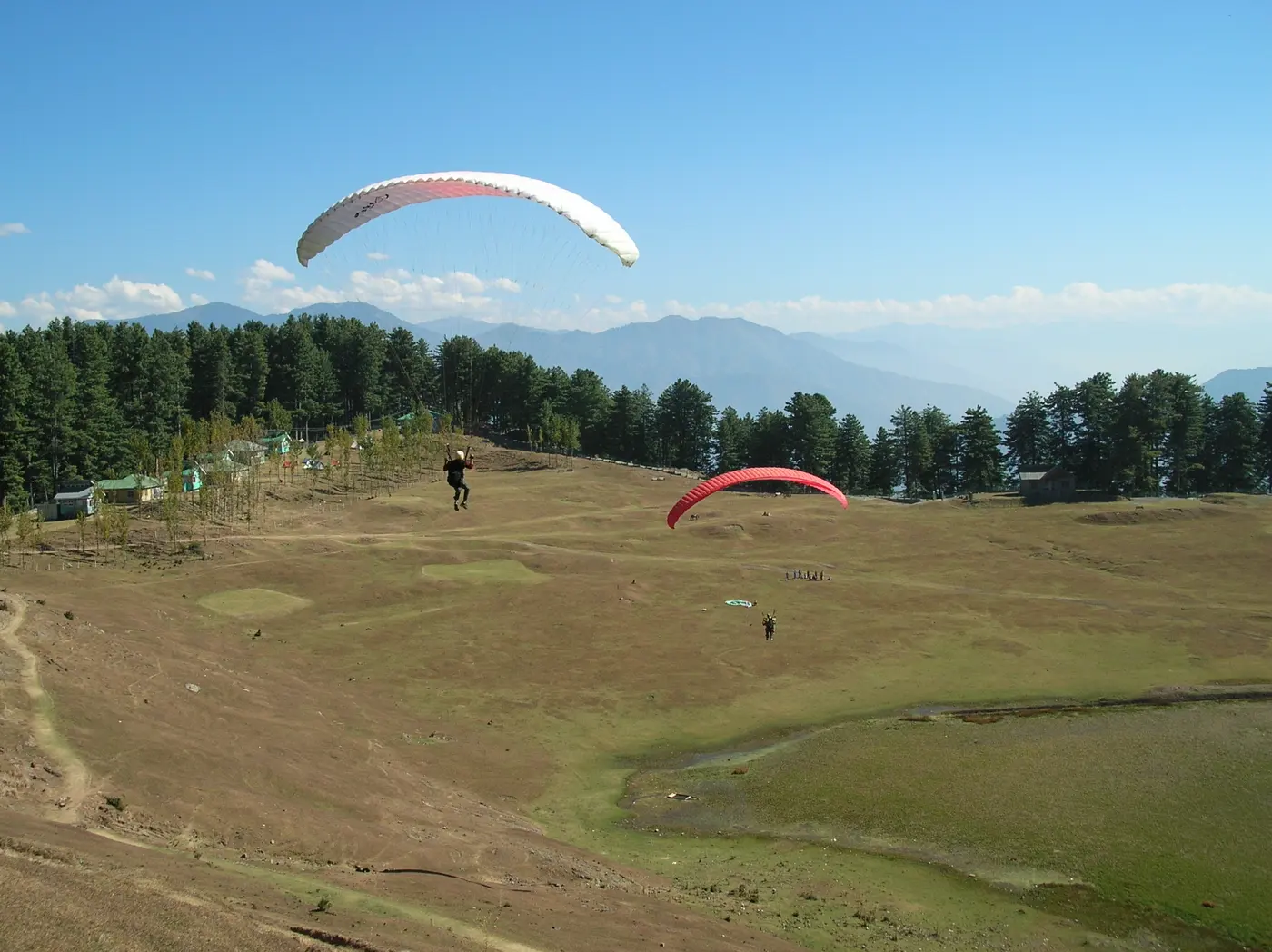 Paraglider launching over the open meadow at Sanasar near Patnitop, Jammu and Kashmir