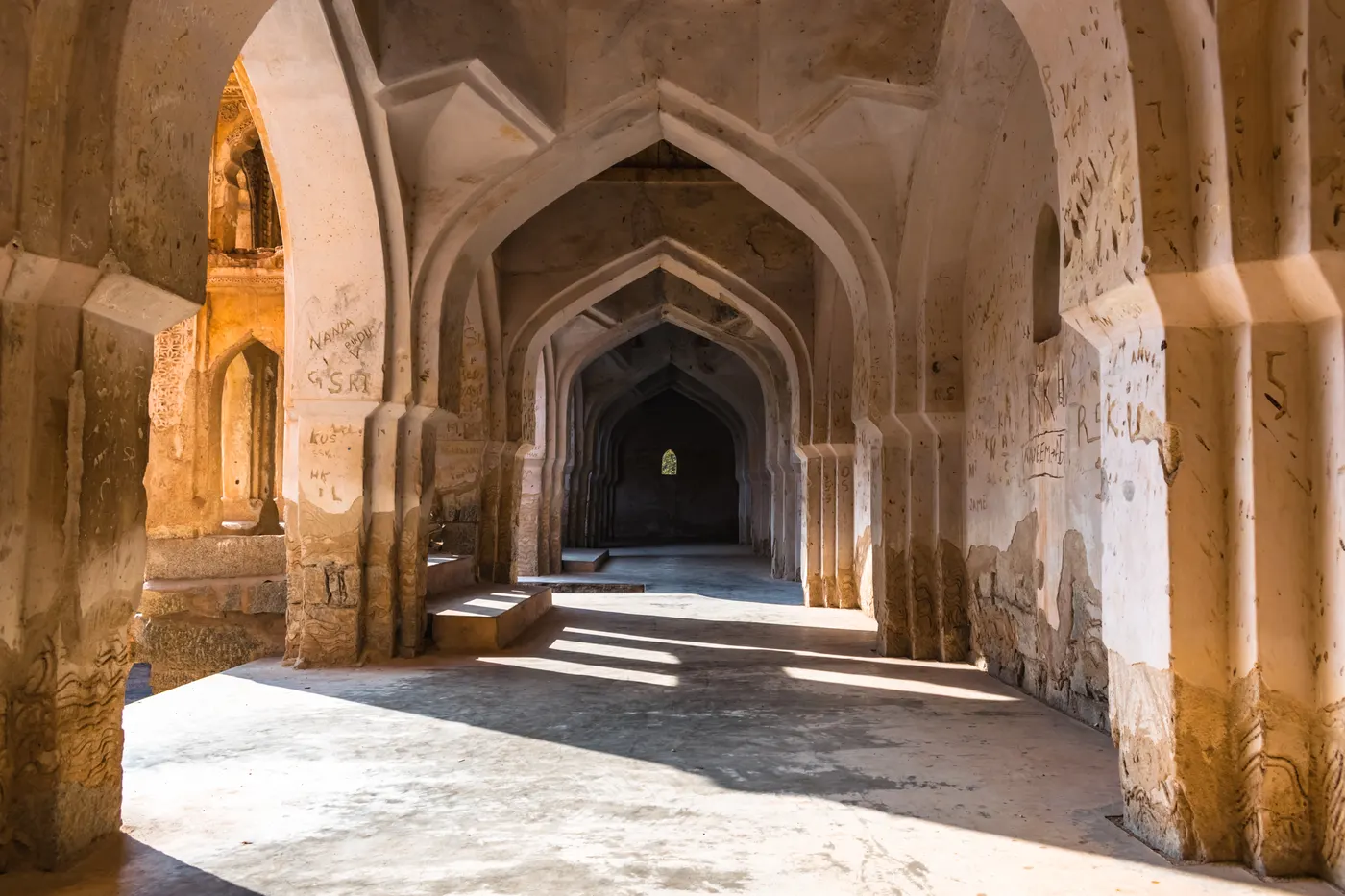 Ornate corbelled arches and balconies inside the Queen's Bath, Hampi