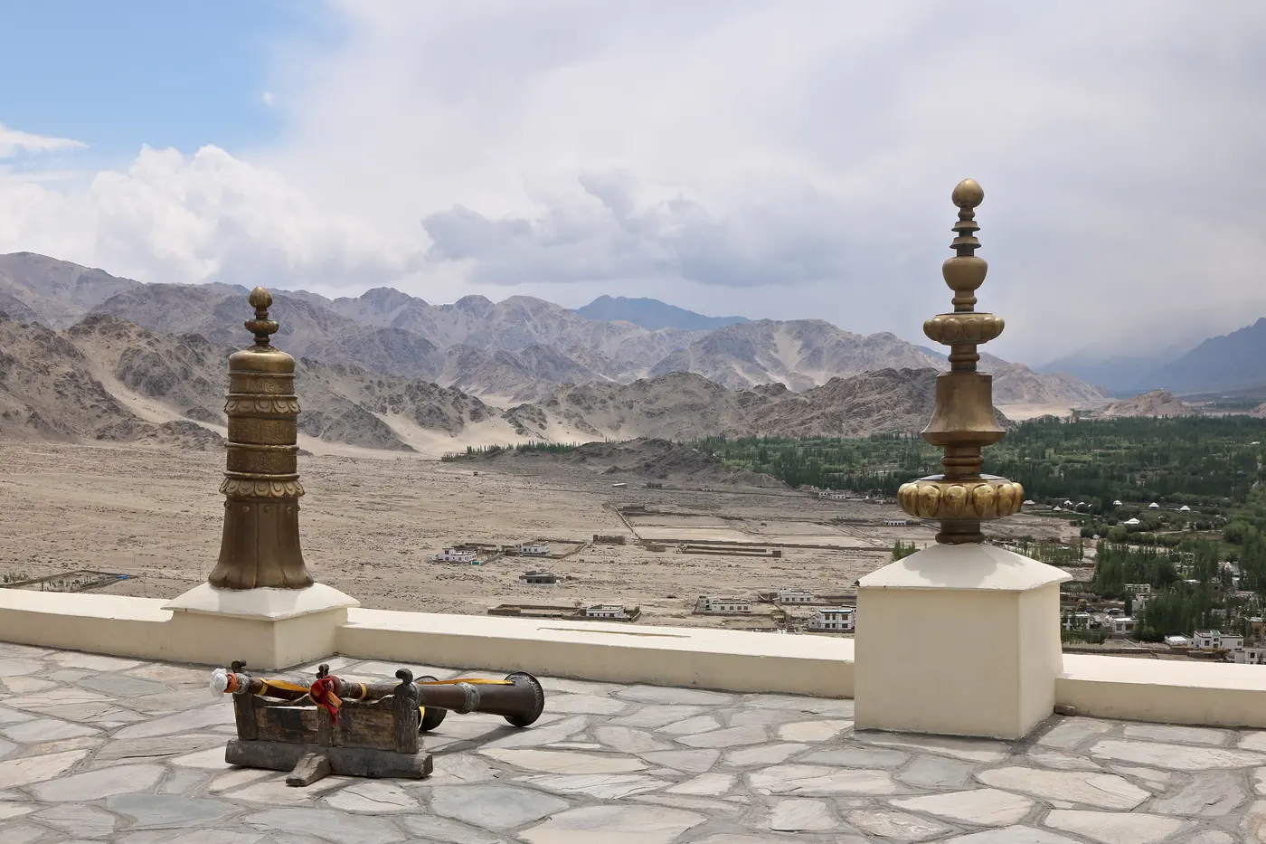 View from Thiksey Monastery's rooftop terrace over brass chorten finials down to the Indus valley and Leh below
