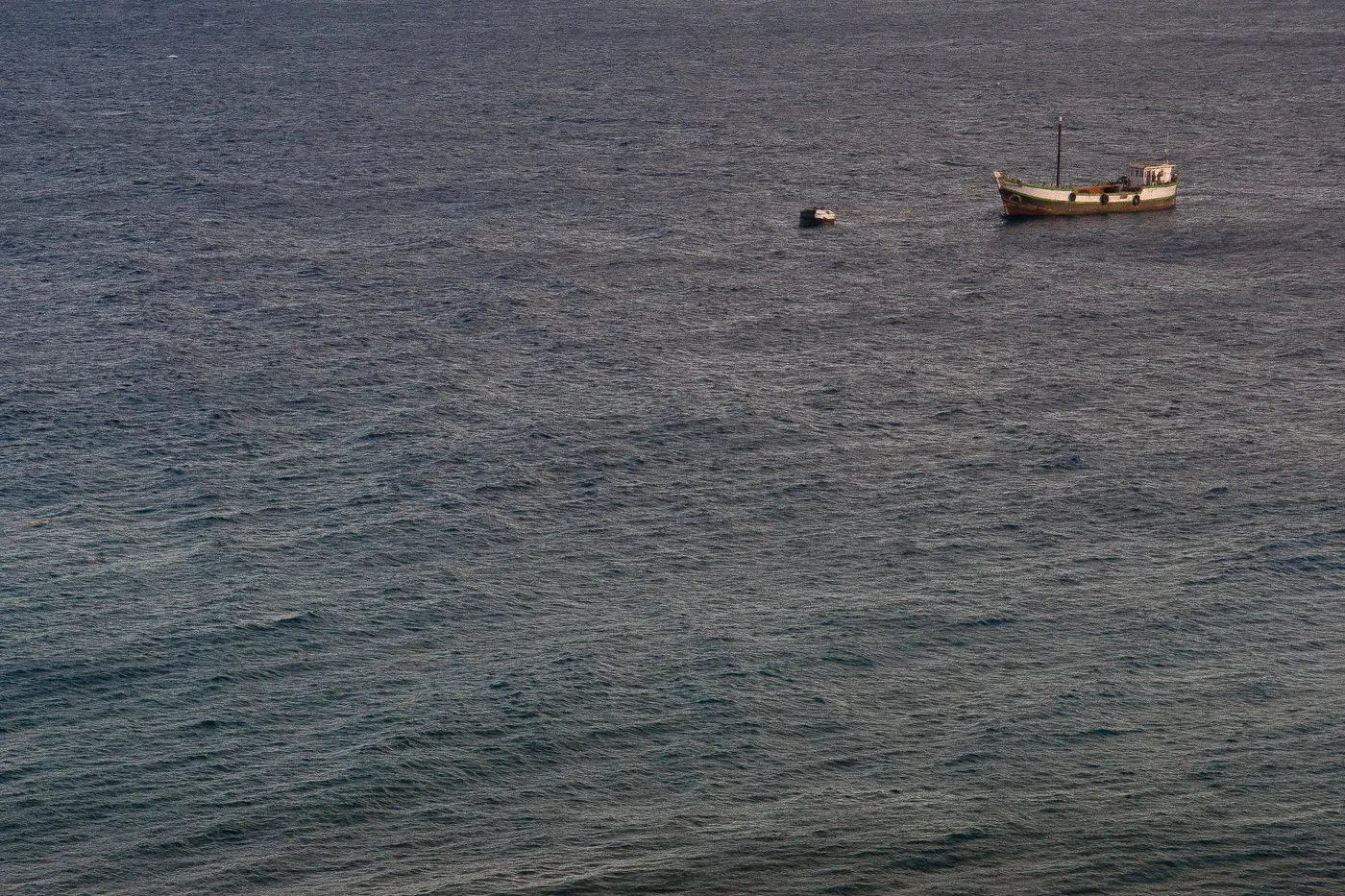 A traditional wooden boat anchored in open water off Kavaratti, used for dive and snorkel trips