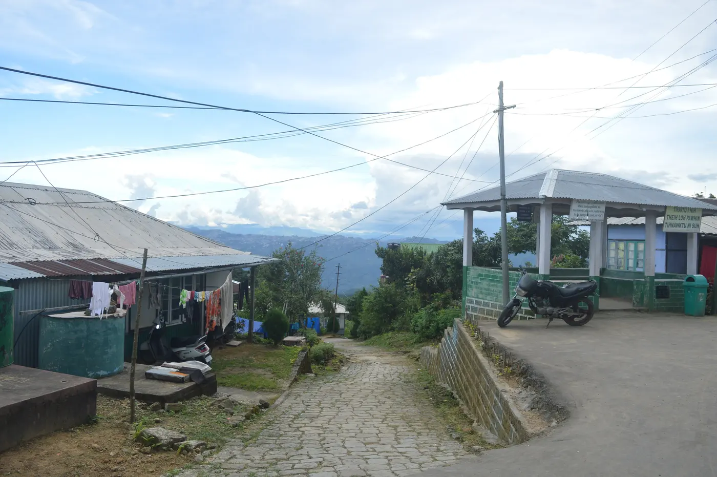 A hillside path through Reiek village with traditional houses and hills stretching into the distance