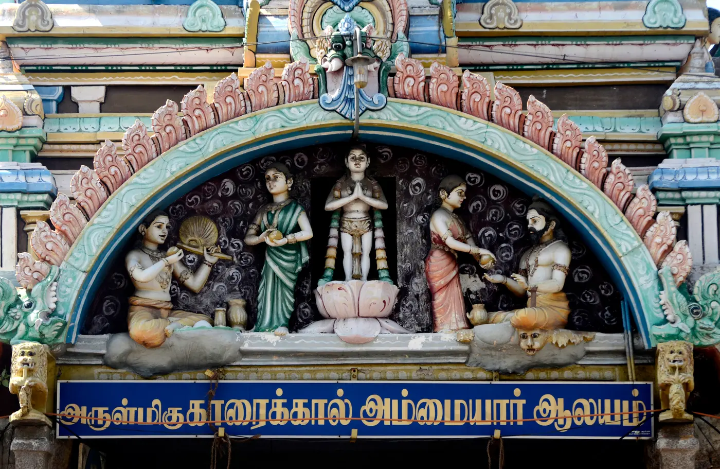 Carved stone relief and signboard at the entrance of Karaikal Ammaiyar Temple in Karaikal town