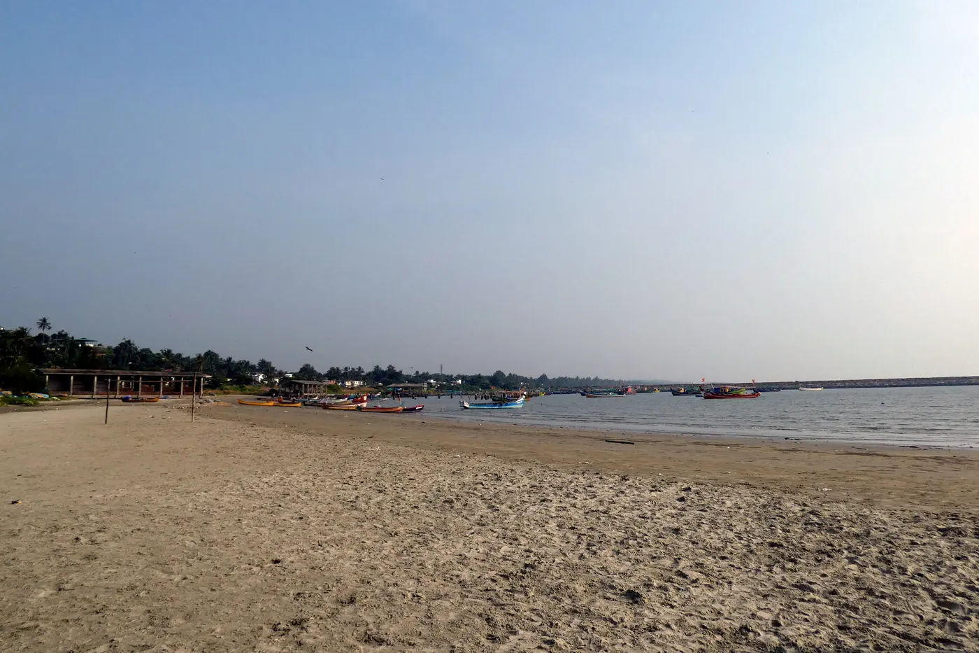Mahe Beach with colourful fishing boats lined along the shore near the river mouth
