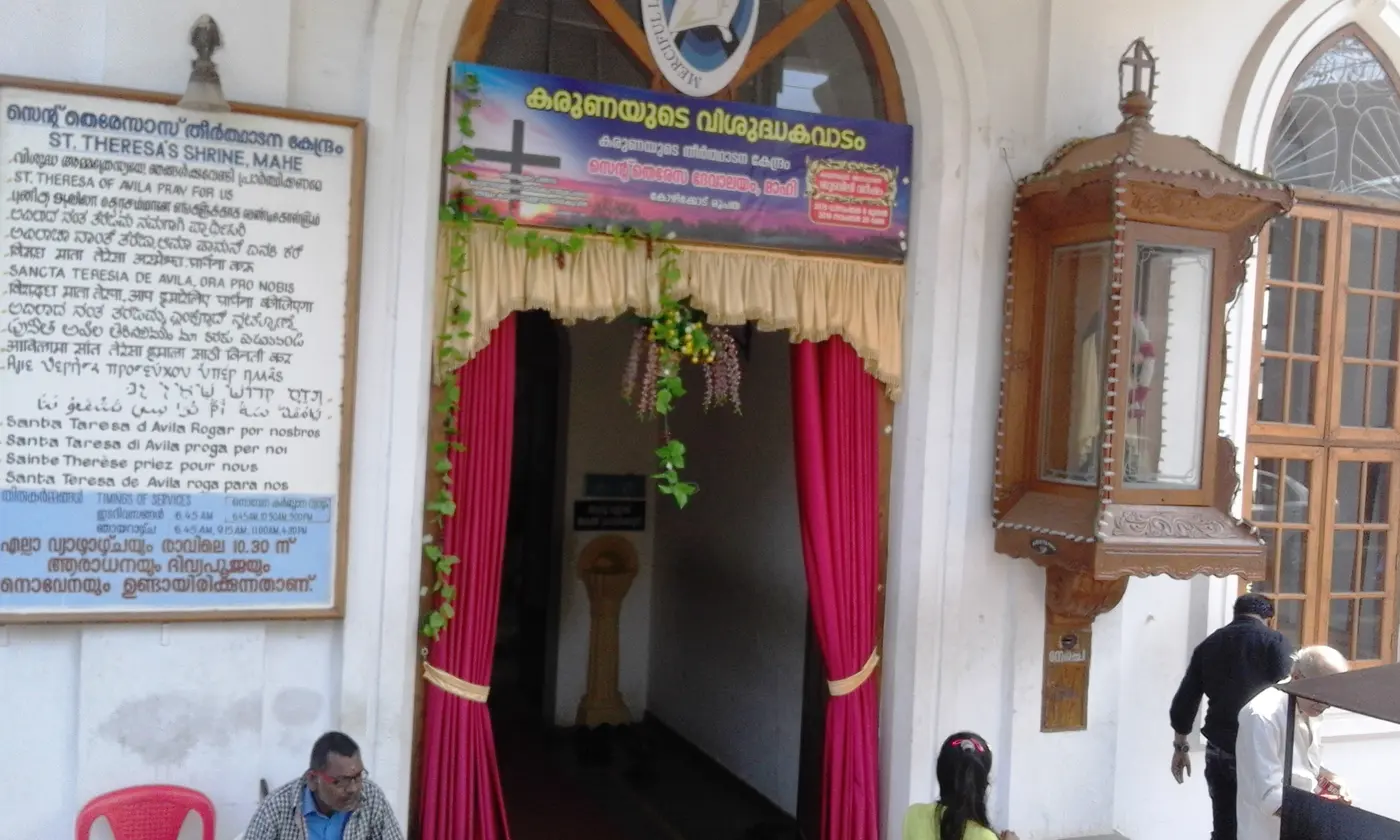 Decorated entrance of St. Teresa's Shrine in Mahe, with the church's name board visible