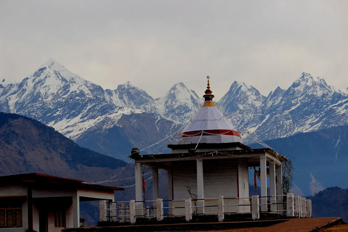 The small white Nanda Devi Temple in Munsiyari town with the snow-capped Panchachuli range behind it