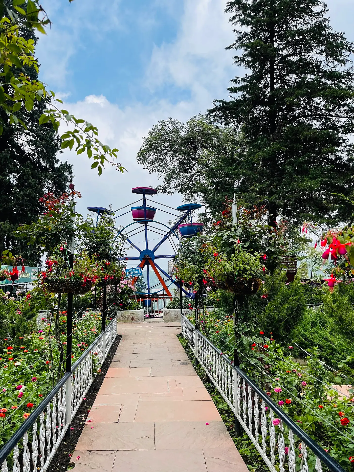 Flower-lined pathway leading to the small Ferris wheel at Company Garden, Mussoorie