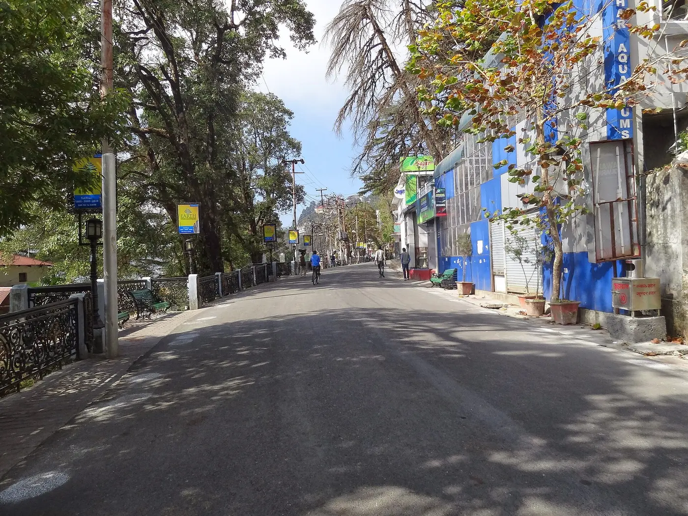 Mussoorie's Mall Road promenade lined with shops and iron railings on a sunny afternoon