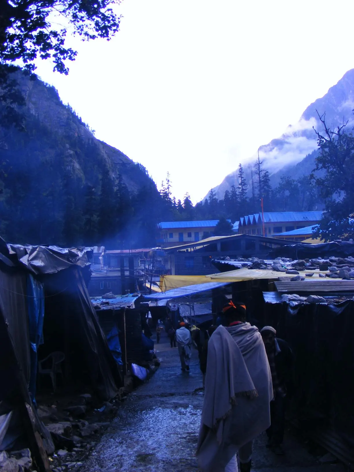 Ghangaria settlement at dusk, tented shops and guesthouses lining the path with mountains behind
