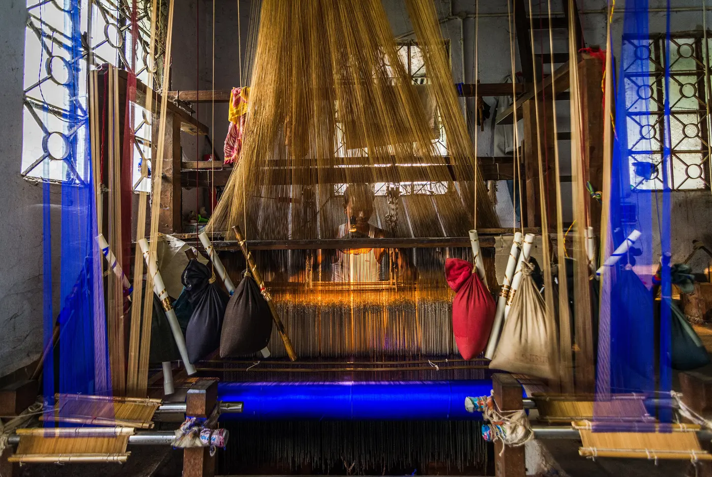 A weaver working a traditional jacquard handloom to produce a Baluchari silk saree in Bishnupur