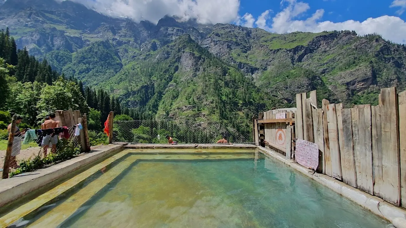 Hot spring pool at Kheerganga with mountains behind