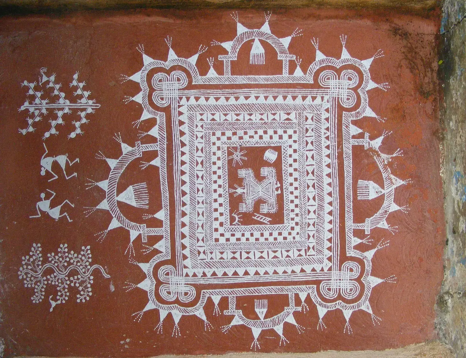 A Warli painting in white on a red wall, at Sanjay Gandhi National Park, Mumbai